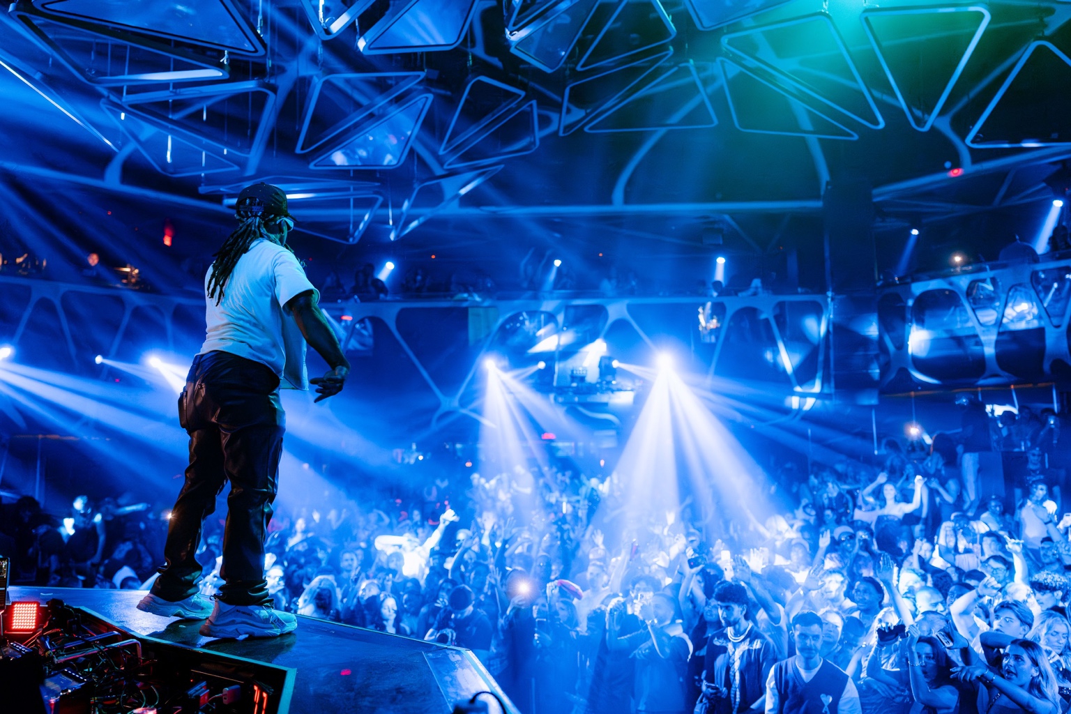 Patrick Cornett facing a blue-lit crowd during a live performance